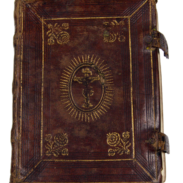 The leather cover of the Noted Hymnal. It is dark red with faded gold detailing and a depiction of Jesus on the Cross in the middle.